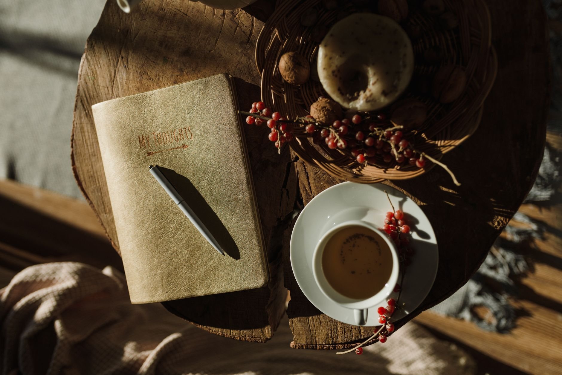 A cozy scene with a notebook, tea cup, and pastries on a wooden table — a calm moment for garden planning